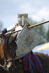 Image:  Medieval knight in full armor on horseback at a jousting competition.