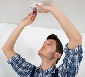 Image: Man testing smoke detector